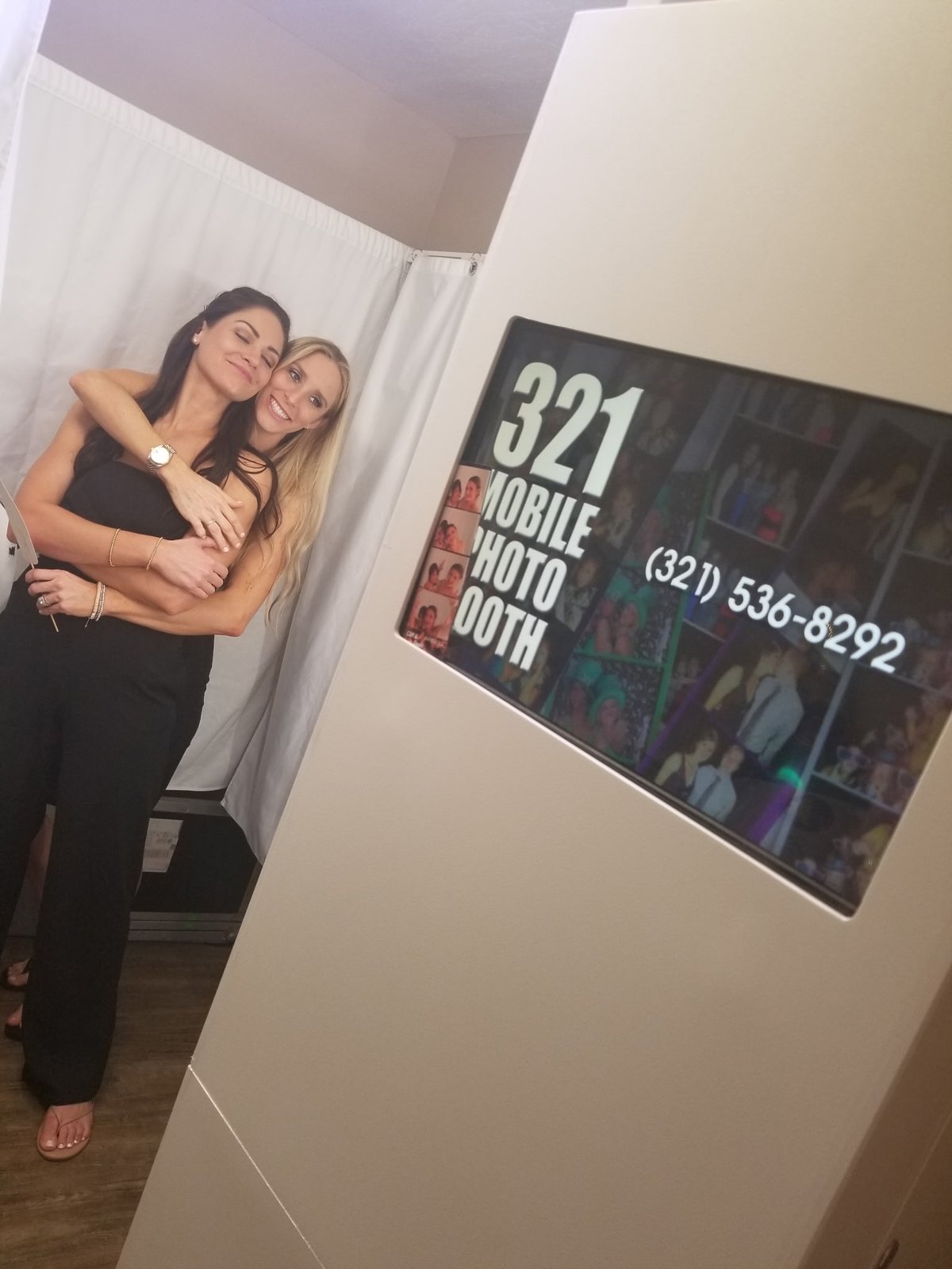 Two guests posing beside the 321 Mobile PhotoBooth kiosk